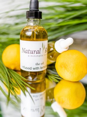 a golden oil bottle with lemon surrounding it